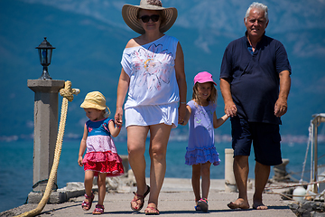 Image showing grandparents and granddaughters walking by the sea