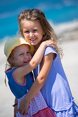 Image showing little sisters hugging on the beach coast