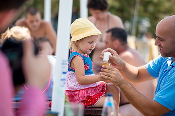 Image showing cute little girl eating ice cream with her young father