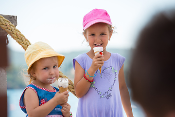 Image showing little girls eating ice cream by the sea