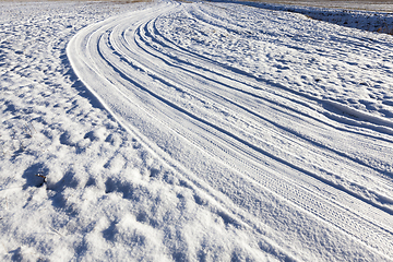 Image showing snow-covered road in a field