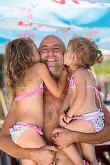 Image showing portrait of young happy father with daughters by the sea