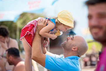 Image showing cute little girl eating ice cream with her young father