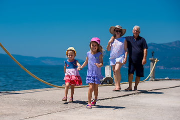 Image showing grandparents and granddaughters walking by the sea
