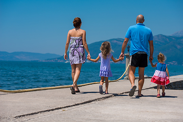 Image showing young happy family walking by the sea