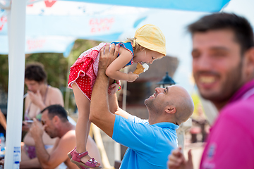 Image showing cute little girl eating ice cream with her young father