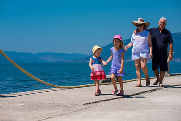 Image showing grandparents and granddaughters walking by the sea