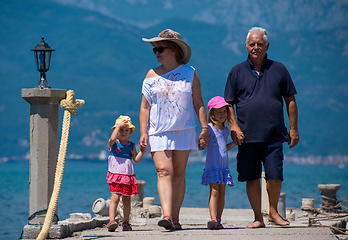 Image showing grandparents and granddaughters walking by the sea