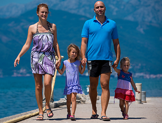 Image showing young happy family walking by the sea