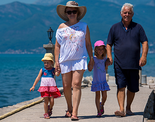 Image showing grandparents and granddaughters walking by the sea