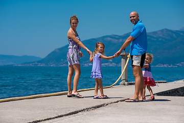 Image showing young happy family walking by the sea