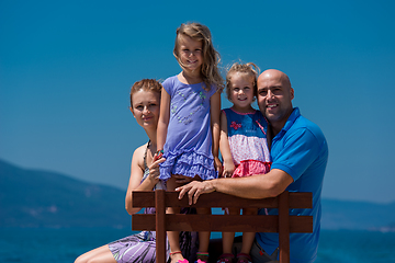 Image showing portrait of young happy family with daughters by the sea