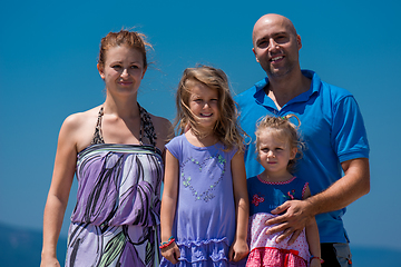 Image showing portrait of young happy family with daughters by the sea