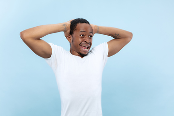 Image showing Half-length close up portrait of young man on blue background.