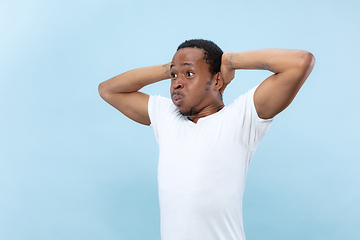 Image showing Half-length close up portrait of young man on blue background.