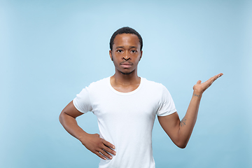 Image showing Half-length close up portrait of young man on blue background.