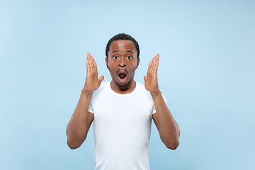 Image showing Half-length close up portrait of young man on blue background.