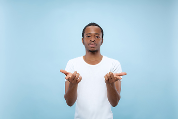 Image showing Half-length close up portrait of young man on blue background.