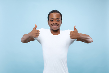 Image showing Half-length close up portrait of young man on blue background.