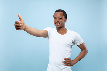 Image showing Half-length close up portrait of young man on blue background.