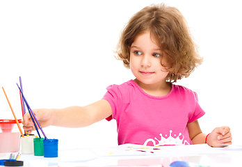 Image showing Little girl is painting with gouache