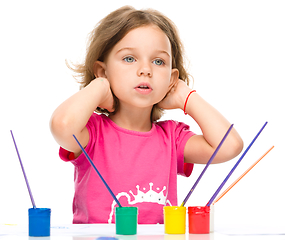 Image showing Little girl is painting with gouache