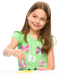 Image showing Little girl is painting with gouache