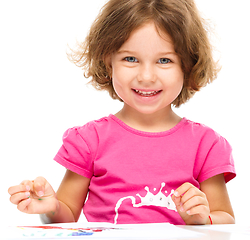 Image showing Little girl is painting with gouache