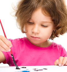 Image showing Little girl is painting with gouache