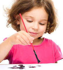 Image showing Little girl is painting with gouache