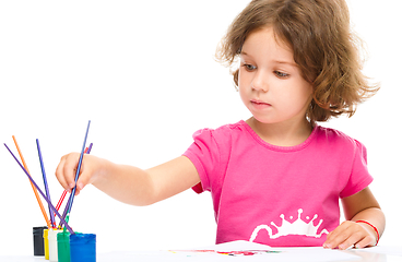 Image showing Little girl is painting with gouache