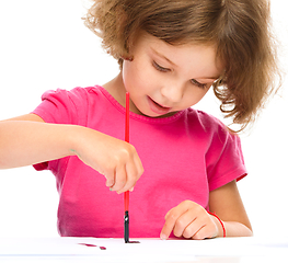 Image showing Little girl is painting with gouache