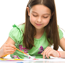 Image showing Little girl is painting with gouache