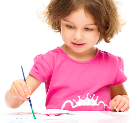 Image showing Little girl is painting with gouache