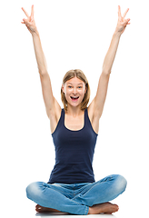 Image showing Young happy woman is sitting on the floor