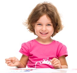 Image showing Little girl is painting with gouache