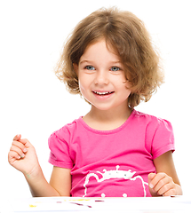 Image showing Little girl is painting with gouache