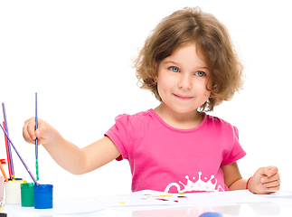 Image showing Little girl is painting with gouache