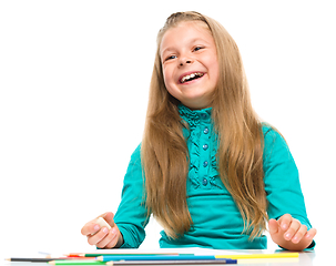 Image showing Little girl is drawing using pencils