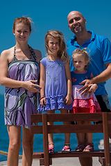 Image showing portrait of young happy family with daughters by the sea