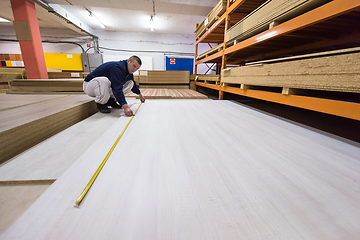 Image showing carpenter measuring wooden board