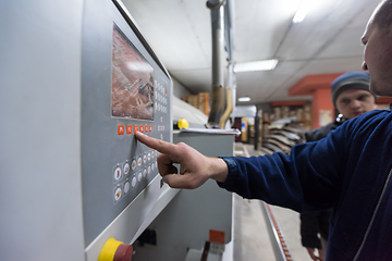 Image showing carpenter calculating and programming a cnc wood working machine