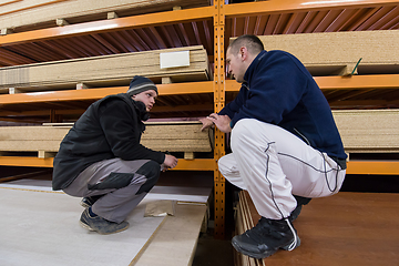 Image showing two young carpenters writing new prices