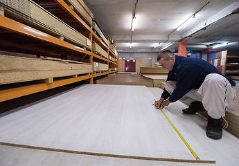 Image showing carpenter measuring wooden board