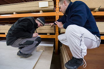 Image showing two young carpenters writing new prices