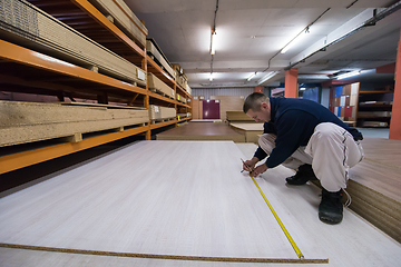 Image showing carpenter measuring wooden board