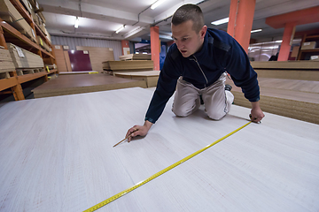 Image showing carpenter measuring wooden board