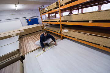 Image showing carpenter measuring wooden board