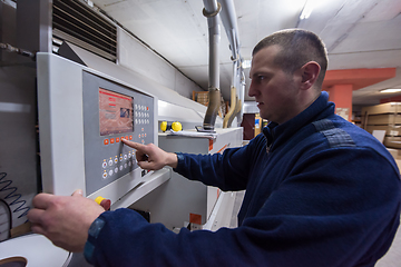 Image showing carpenter calculating and programming a cnc wood working machine