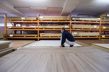 Image showing carpenter measuring wooden board